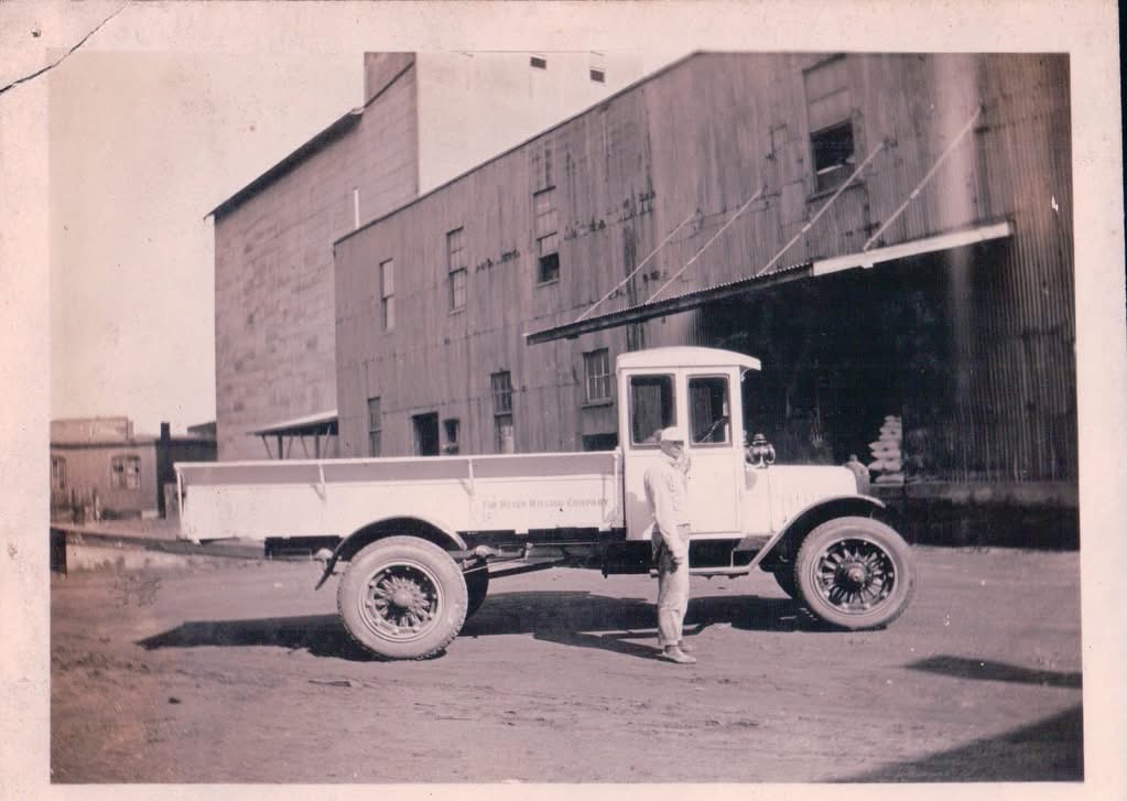 Vintage delivery truck and man outside industrial warehouse